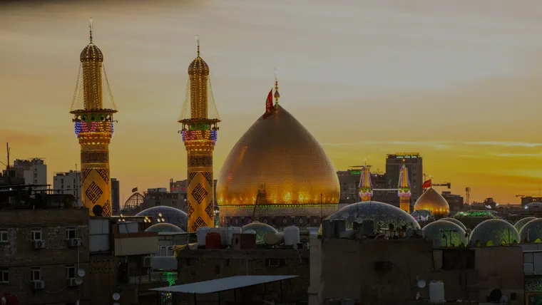 گنبد طلایی و گلدسته‌های حرم مطهر امام حسین (ع) در کربلا، هنگام غروب